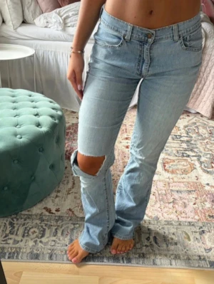 Ljusblå bootcut jeans med hål - Säljer ett par ljusblå bootcut jeans. Från Levis passar xs-m
