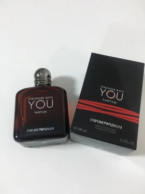 Emporio Armani Stronger With You Parfum - Emporio Armani Stronger With You Parfum i en mörkbrun, fyrkantig glasflaska med silverfärgad rund kork. Parfymen kommer i originalkartong med stilren svart design och röda detaljer. Flaskan rymmer 100 ml och har en lyxig känsla.