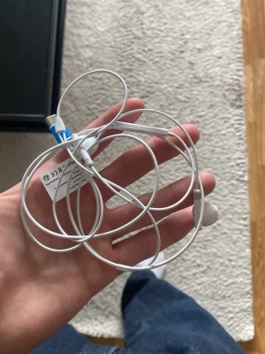 Vita trådbundna USB-C hörlurar - Säljer ett par vita trådbundna hörlurar med USB-C kontakt. Hörlurarna har in-ear design och sladd i plast. Perfekta för dig som vill ha ett enkelt och smidigt alternativ till mobilen eller datorn. Dom är oanvända