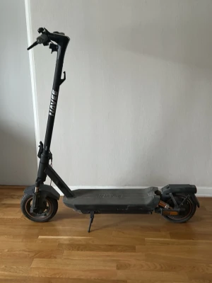Svart Elsparkcykel  - FUNKAR BARA ATT KÖPA DEN OM NI KAN HÄMTA DEN I TUMBA. Säljer en svart elscooter (Ny pris 6000kr) från Naave med digital display på styret och bred fotplatta. Scootern har robusta hjul, stöd och tydliga handtag. Perfekt för smidig transport i stan eller till skolan. Ingen tydlig tecken på användning och använd under en sommar.                    Motorstyrka: 400 W - 1000 W Hastighet:  32 km/h Bakhjulsdriven 75 km räckvidd Fyrdubbelt stötdämpningssystem. När den är köpt rengörs den!