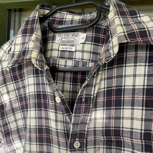 Rutig skjorta från Ralph Lauen - Klassisk rutig skjorta från Polo Ralph Lauren Jeans Company i svart, vit och beige. Slim fit-modell med knappar framtill och mjukt bomullsmaterial. Perfekt för dig som gillar en tidlös och avslappnad stil.