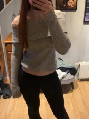 Beige off shoulder stickad tröja - Trendig beige stickad tröja med off shoulder-design och långa ärmar. 