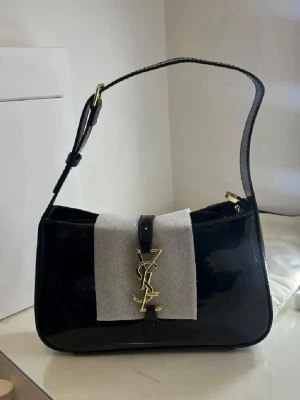 Axelväska - Svart yslL väska helt oanvänd, axelbandet kan man ändra storlek på. Helt oanvänd