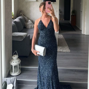 Mörkblå glittrig långklänning från Dressroom Linné - Säljer nu min fantastiska balklänning från Dressroom Linné. Klänningen är glittrig med paljetter och har en v-ringad design. Jättefin passform, skriv gärna till mig om ni har frågor eller vill ha fler kort❤️ Har lämnat in den hos skräddare efter användning så den är i helt nyskick! Därav detta priset!! Så alltså är klänningens pris 4990+800kr, men säljer för 3000kr🥰påsen medföljer och även en massa extra paljetter som jag bett om!🥰 