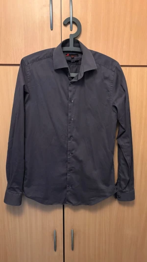 Mörkgrå skjorta från Dressmann - Riktigt snygg mörkgrå skjorta från Dressmann i slim fit-modell. Knappt använd men har tyvärr tröttnat på den. Hör av vid minsta tvek.