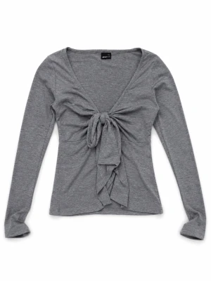 Grå långärmad topp med knyt - Superfin grå långärmad topp från Gina med v-ringning och snygg knytning framtill. Den passar både xxs och xs Toppen är figurnära och har en croppad passform som ger en trendig look. Perfekt att styla med jeans eller kjol för en fin vibe.