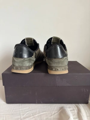 Valentino rockrunners - Snygga sneakers från Valentino med camomönster i grönt, beige och svart. Skorna har detaljer i mocka och läder, samt en gummisula med nitar på hälen. Perfekta för dig som vill sticka ut med en unik och trendig look. FRI FRAKT