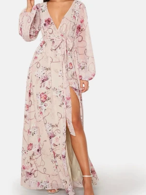Lång blommig omlottklänning med bälte - Romantisk långklänning i ljusbeige med blommigt mönster i rosa, lila och vitt. Omlottmodell med v-ringning, långa puffärmar och avtagbart midjebälte. 