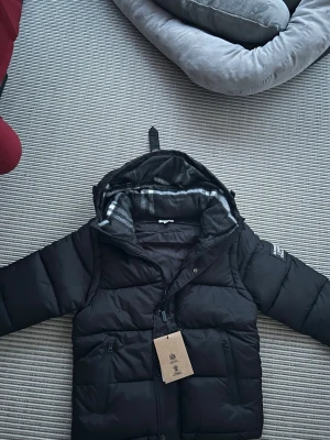 Burberry jacka/ väst - En burberry jacka som blir till en väst om man tar av armarna. Perfekt till både kommande höst och vinter. Till och med kallare sommar dagar om man vill ha en väst. Storlek S och perfekt skick.