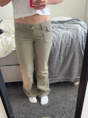 Beiga bootcut jeans med låg midja - Snygga beiga jeans med bootcut passform och låg midja. Jeansen har klassiska fickor fram och bak samt bälteshällor. Perfekta för dig som gillar en avslappnad men trendig stil. Aldrig andvända!!