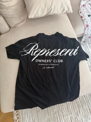 Svart Represent t-shirt med tryck - Snygg svart t-shirt från Represent med stort vitt tryck på ryggen och mindre logga framtill. Klassisk passform med rund hals och korta ärmar. Perfekt för dig som gillar streetwear och vill sticka ut med en stilren look.