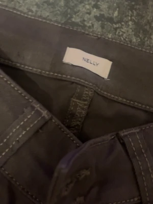 Bruna utsvängda, långa, låg midjade jeans från Nelly - Säljer ett par bruna jeans från Nelly med utsvängd passform och klassisk femficksdesign. Jeansen har synliga sömmar och är tillverkade i ett slitstarkt bomullsmaterial. Perfekta för en avslappnad och trendig look. De är gjorde för långa tjejer vilket jag inte är, därför säljer jag. Har aldrig använt.