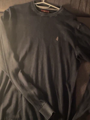 Mörkblå Tröja - MCS - Mörkblå stickad tröja från MCS med rund halsringning och diskret broderad logga på bröstet. Tröjan har långa ärmar och ribbade muddar vid ärmslut och nederkant. Perfekt för lager-på-lager och klassisk stil. Passar till en grå hoodie som jag säljer perfekt!