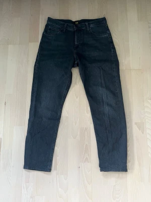 Svarta raka jeans från Lee - Säljer ett par svarta jeans från Lee med klassisk femficksdesign och raka ben