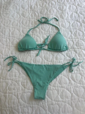 Mintgrön Calzedonia bikini  - Snygg mintgrön bikini från Calzedonia med trekantsöverdel och knyt både i nacken och ryggen. Underdelen har knyt i sidorna för justerbar passform. Säljer då den är för liten och har bara används 2 gånger. Orginalpris var 730kr totalt för både under och överdel.