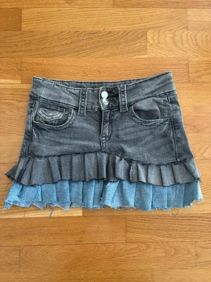 Grå jeanskjol med volang från Gina Tricot - Säljer Gina Tricots gråblå jeanskjol. Storlek 152, men passar xs-s. Jag skulle tro att den tidigare säljaren har trimmat de här jeansen själv. Bra skick. 🤍