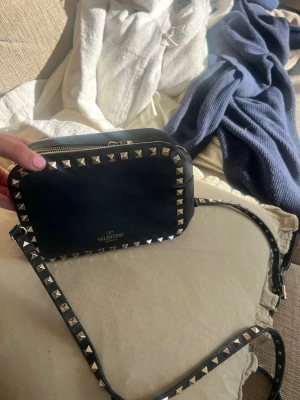 Valentino Väska med defekt - Säljer min valentino väska som utseende mässigt är i fin fint skick. Däremot så har den en defekt. Vilket visas på 5 & 6 bilden. Det är hakarna som låstnat. Går att fixa hos skräddare eller skomakare. Därav säljer jag billigt! 1500kr så kan man själv gå till skomakare och fixa den. Går säkert att fixa hemma om man är lite pillig. Äkthetsbevis finns! Ställ gärna fler frågor! 