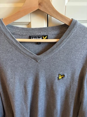 Grå tröja Lyle & Scott - En grå V-ringad tröja från Lyle & Scott. Stl L och tröjan är aldrig använd! 