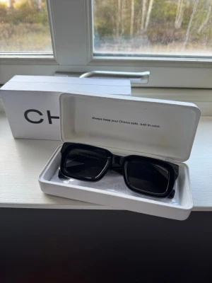 Chimi 05 - Stilrena svarta solglasögon från Chimi med rektangulära bågar och mörka linser. Bågarna är tillverkade i syntetmaterial och har en modern, chunky design som ger en cool vibe. Perfekt för dig som vill ha en trendig look i sommar. Har används max 10 gånger