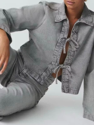 Grå jeansjacka med knytning - grå jeansjacka i croppad modell med två knytband framtill istället för knappar. Använd 2-3 gånger🧡kan självklart skicka bilder vid förfrågan 