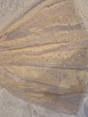  Barnkläder i olika storlekar  - Säljer en magisk Frost-inspirerad prinsessklänning med blått och lila tyllkjol och glittriga detaljer. Livet har motiv från Frost och tunna axelband i kors. Perfekt för maskerad eller cosplay som isprinsessa.