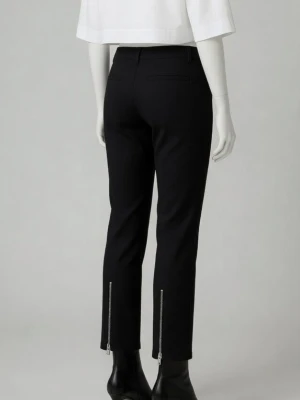 Svarta smala byxor med dragkedjor på benen, från ATT/ÅHLÉNS. Strlk 34. - Svarta smala byxor med silverfärgade dragkedjor på benen, från ATT/ÅHLÉNS. Strlk 34. Begagnade men inte trasiga etc. Stängs med dragkedja och knapp. Material: Bomull. Skyltdockan visar liknande byxa och passform.