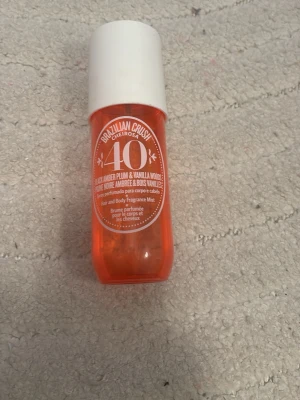 Brazilian Crush Cheirosa 40 parfymmist - Brazilian Crush Cheirosa 40 är en parfymmist från Sol de Janeiro med en orange plastflaska och vit kork. Doften har inslag av svart plommon och vaniljträ. Perfekt för att spraya på både kropp och hår. Flaskan är smidig och lätt att ta med.