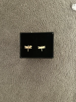 Guldörhängen med trollslända - Snygga örhängen i guldfärg med små trollsländor som hängsmycke. Örhängerna är ifrån ”timi of sweden” och är nickelfria. De är små och enkla att ta med sig överallt. De är inte tunga.💛