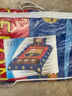 FC Barcelona bäddset med klubbmärke - Säljer ett färgglatt bäddset med FC Barcelona-motiv. Setet har klubbens emblem och färger: blått, rött, gult och inslag av vitt. Materialet är quiltat tyg och setet innehåller både påslakan och örngott med tryck. Perfekt för fotbollsfans!