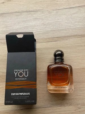 Emporio Armani Stronger With You Intensely - Emporio Armani Stronger With You Intensely är en parfym för män med en elegant, fyrkantig glasflaska i brun och transparent nyans. Flaskan har en rund, mörk kork och kommer med en stilren svart kartong med kopparfärgade detaljer. Volymen är 50 ml.