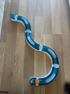 Kattleksak  - Rolig och aktiverande leksak för katt! Består av flera delar som sätts ihop till en bana där en boll med ljus rullar runt, perfekt för att hålla katten sysselsatt och stimulerad.