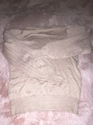 Beige stickad tröja med ribbade puff ärmar - Säljer en beige stickad tröja från KAFFE i storlek XS-S med en tajt passform men lös i puffärmarna. Väldigt fin och endast använd en gång, tröjan heter KAlone Knit Pullover. Köpt för 599!