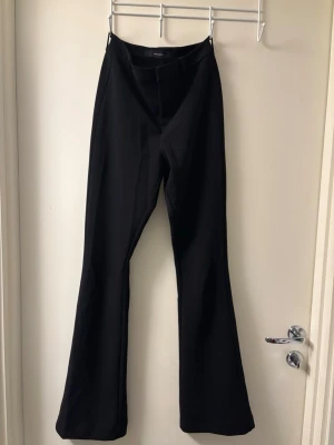 Svarta bootcut kostym byxor  - Säljer ett par svarta bootcut kostym byxor från vero Moda . De har en hög midja och är gjorda i ett mjukt och stretchigt material som sitter snyggt. Perfekta för dig som gillar en stilren look med lite extra flair i benen.