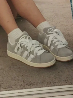adidas Originals Sneakers Campus 00s grå - Snygga höst/vår skor🌸                                              Det är ett par Adidas Campus sneakers i grå mocka och vita detaljer. Dom är lite gamla har använt dom en del där av de låga proset.           Ny pris är 1200kr men pga att dom är slitna är pristet lågt går också att diskuteras🥰