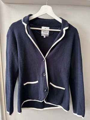 Marinblå kofta  - Blå kofta med vita detaljer, storlek S, märket på koftan finns med på sista bilden 😇 mycket bra skick