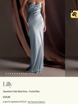 blå balklänning i satin - Elegant långklänning i frostblå satin med sweetheart-urringning och smala axelband. Klänningen har en slät och glansig yta som ger ett lyxigt intryck. Perfekt för dig som vill ha en stilren och modern look. Liten defekt (se sista bilden)