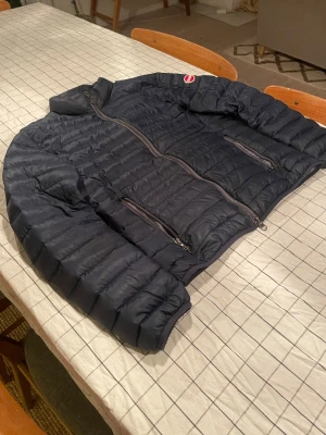 Svart pufferjacka från Colmar - Säljer en svart pufferjacka från Colmar Originals med quiltad design och två praktiska dragkedjefickor. Jackan har långärmad passform och hög krage som skyddar mot kyla. Perfekt för dig som vill ha en stilren och funktionell vinterjacka.