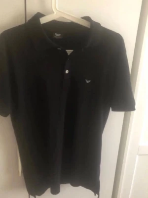 Armani Piketröja - Säljer en elegant och tidlös pikétröja från Armani. En riktig garderobsklassiker som kombinerar hög kvalitet med en stilren, minimalistisk look. Passar perfekt till både vardag och mer klädda tillfällen.