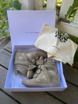 Isabel Marant Bekett - Säljer mina älskade Isabel Marant Bekett sneaker med kilklack. Storlek 36. Färgen är beige/taupe. Allt som jag fick med när jag köpte skorna medföljer, dvs skolåda och två dustbags. Nypris 6500kr, denna färg finns inte att köpa längre.