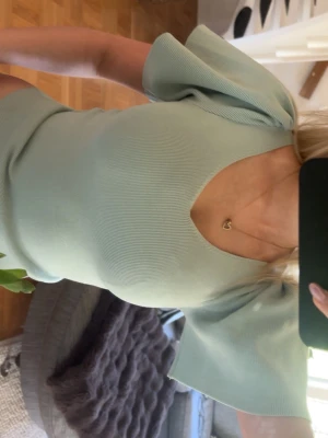 Topp - Superfin ljusgrön topp med v-ringning och korta, vida ärmar. Toppen har en croppad passform som sitter snyggt på kroppen. Perfekt att styla med jeans eller kjol för en trendig look.