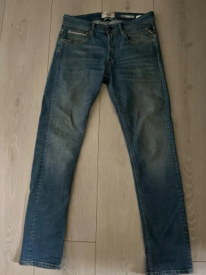 Blå slim fit jeans från Replay - Säljer ett par jeans från Replay i storlek 32/32 med klassisk femficksdesign och snygga slitningar. Jeansen har normal midja och raka ben. Tillverkade i mjukt denimtyg som ger en skön känsla och cool look. Byxorna är sparsamt använda😇👖