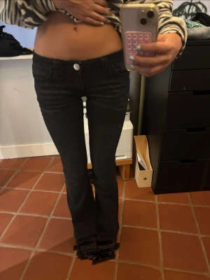 Svarta bootcut jeans med fickor - Säljer ett par svarta bootcut jeans med snygga bakfickor och klassisk femficksdesign. Jeansen är lågmidjade från Gina tricot Young 🩷 modellen är i tall och jag är lite över 170 och de är långa på mig. 