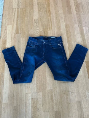 Mörkblå slim fit jeans från Replay - Snygga mörkblå skinny jeans från Replay med klassisk femficksdesign och dragkedja. Jeansen har en smal passform och är tillverkade i stretchigt denimtyg för extra komfort. Perfekta för en trendig och avslappnad look.