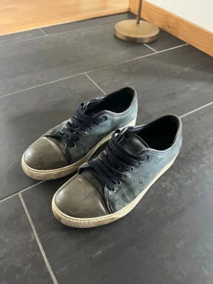 Lanvin cap toe 40 - Snygga marinblå och gråa Lanvin cap toe. Skorna har marinblå skosnören och vit sula. Perfekta för en avslappnad streetstil och passar till det mesta i garderoben. Storlek 40. 