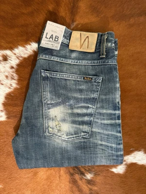 Nudie SelvageLab LabJoe7 AvrageJoe - Tjena! Säljer dessa galet sällsynta Nudies, modellen är ifrån nudie Lab kollektion som tillverkades mellan 2009-2013, just detta paret är ifrån antingen 2009 eller 2010 och hade en prislapp på runt 4500kr viket gör dessa extremt sällsynta i detta skicket, W34/L32, Hör av dig vid funderingar!🙌