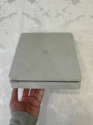 Ps4 Vit Slim - Säljer en vit PlayStation 4 Slim från Sony. Konsolen har en stilren, fyrkantig design med rundade hörn och är tillverkad i plast. På baksidan finns HDMI, USB och nätverksportar. Perfekt för gaming och streaming. En ps4 som har använts ett par gånger, men den fungerar väldigt bra. Den har absolut inga skador i som exempelvis systemet. Alla kablar ingår, enda saken är du behöver är en Tv och en kontroll