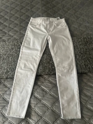 Vita jeans från ONLY - Säljer ett par HELT NYA  vita jeans från ONLY med klassisk femficksmodell och normalhög midja. Jeansen har bälteshällor och stängs med dragkedja och knapp. Perfekta för dig som vill ha en clean och fräsch look. 