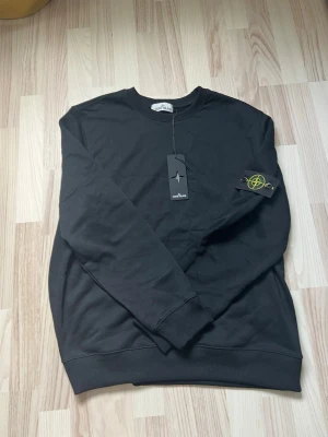 Svart Stone Island sweatshirt - Svart sweatshirt från Stone Island, helt ny . Säljer den för den är för stor. Hör av er om frågor m.m!
