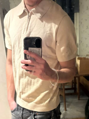 Pike - Snygg beige polotopp med kort ärm från Jack And Jones. Klassisk krage och relaxed fit, perfekt till jeans eller shorts. Materialet känns mjukt och bekvämt mot huden
