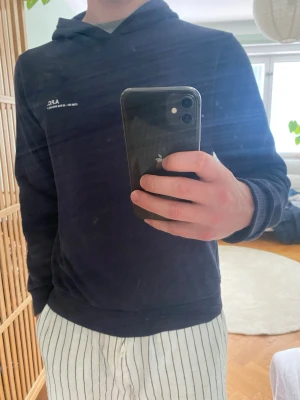 Mörkblå hoodie från A.P.C. - Snygg mörkblå hoodie från A.P.C. med minimalistisk vit logga på bröstet. Hoodien har huva, ribbade muddar och är tillverkad i mjukt bomullsmaterial. Perfekt för en clean och avslappnad stil. Inget äktahets bevis tyvär.